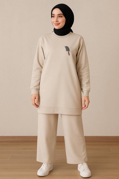 طقم حجاب نسائي أنيق وراقي بلون البيج، قطعتين، يتكون من تونيك بياقة مستديرة وبنطال، ومزين بتفاصيل حجر الطائر
